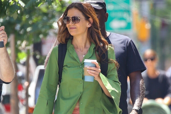Katie Holmes walks in New York City wearing a green shirt with salmon pink pants