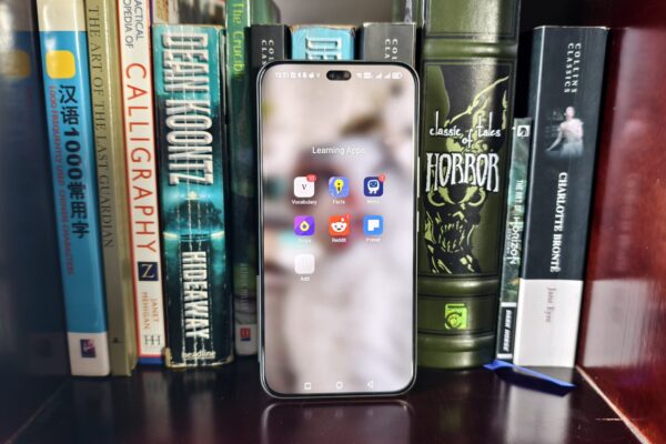 6 free Android apps I use to learn something new every day a learning apps folder on a smartphone in front of a range of books