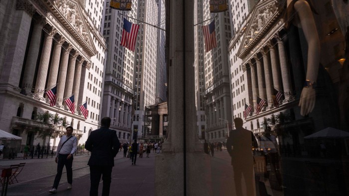 A reflection of a window shows the New York Stock Exchange