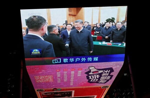 A giant screen shows news footage of Chinese President Xi Jinping shaking hands with Alibaba Founder Jack Ma