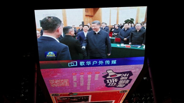 A giant screen shows news footage of Chinese President Xi Jinping shaking hands with Alibaba Founder Jack Ma