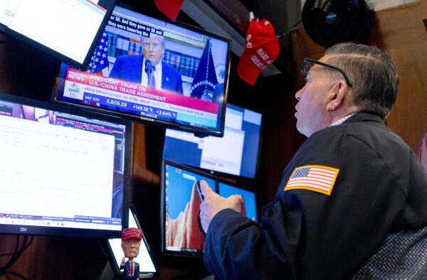 US President Donald Trump is seen on a television screen while a trader works on the floor of the New York Stock Exchange