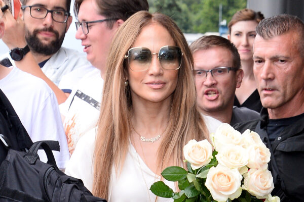 Jennifer Lopez wears a white dress with cage heels while arriving in Warsaw