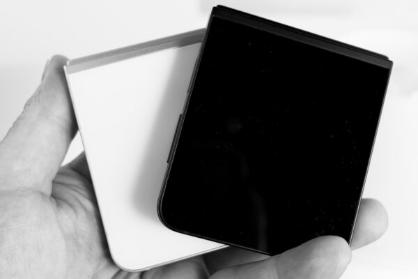 Two Samsung Galaxy Z Flip 7 FE devices in black and white closed in hand