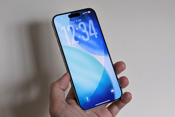 iPhone in hand running iOS 26