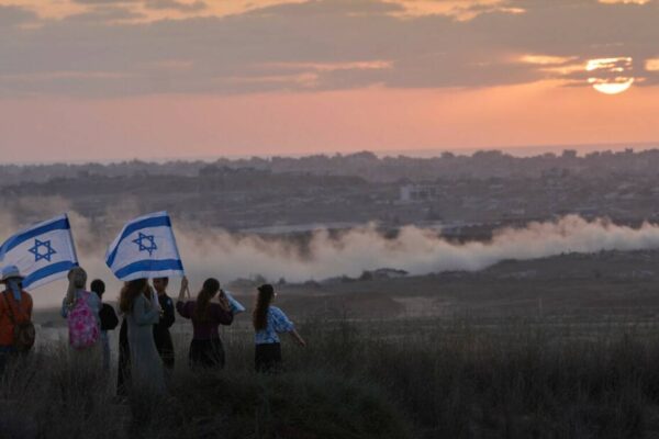 Israeli right-wing activists watch the northern Gaza Strip during a rally calling for the re-es ...