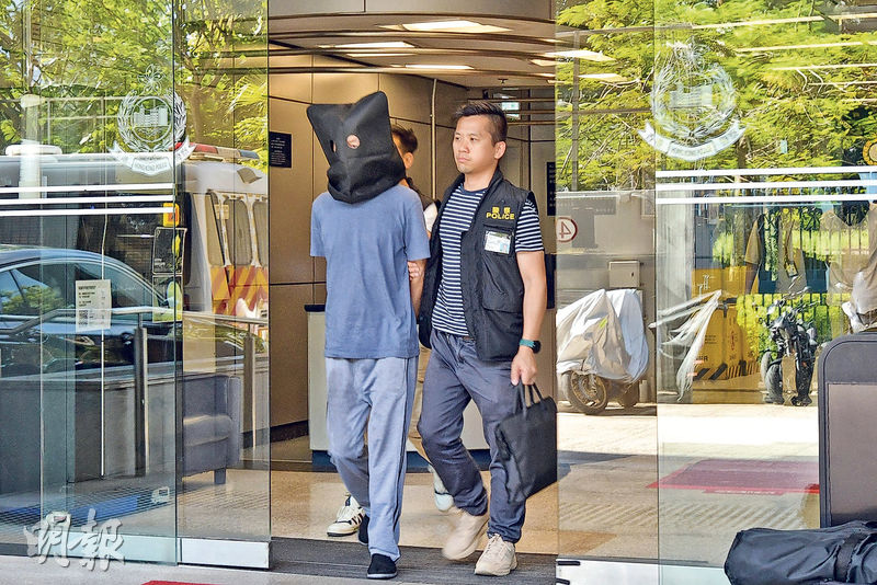 其中一名詐騙集團骨幹成員昨被警方黑布蒙頭帶署調查。（衛永康攝）