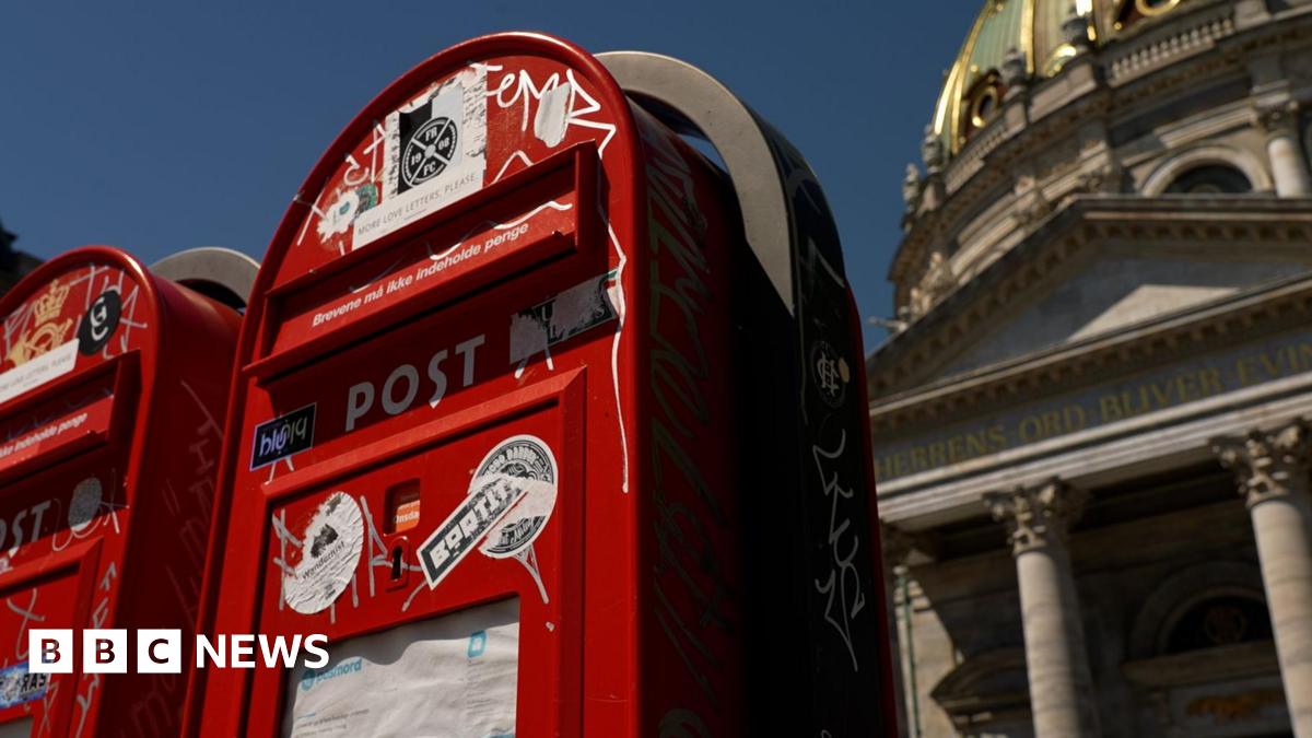 A Cambodian soldier stands on guard near a destroyed building at the border between Thailand and Cambodia. He watches a team of soldiers and officials inspecting the site.