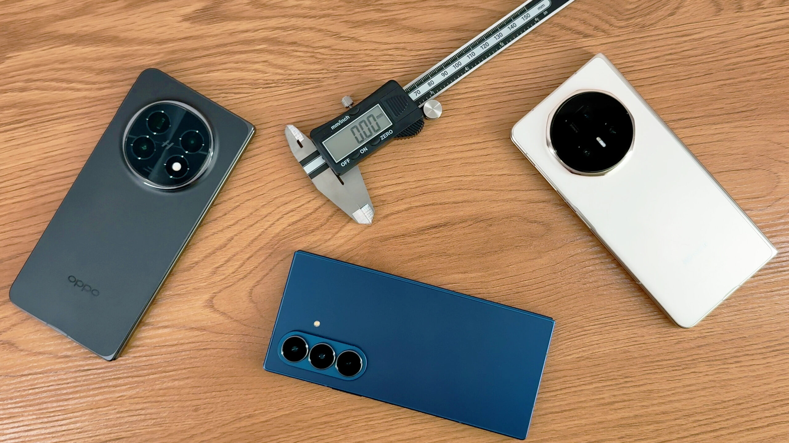 Oppo Find N5, Samsung Galaxy Z Fold 7 and Honor Magic V5 on a table with some digital calipers