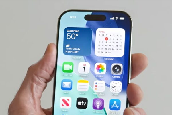 A person holding an iPhone running iOS 26.