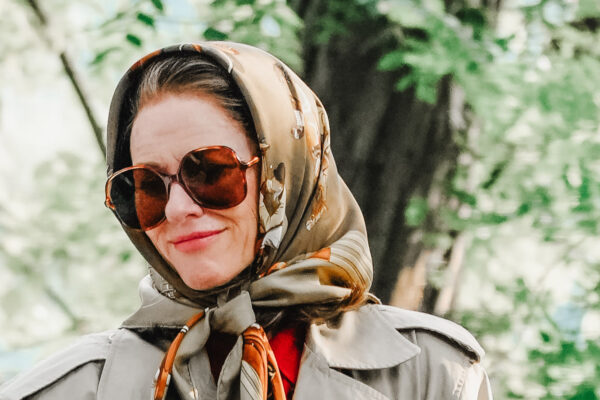 Naomi Watts on set for American Love Story wearing a silk scarf and oversized sunglasses