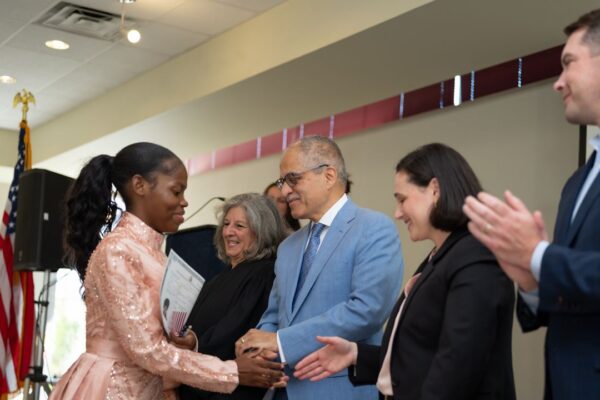 A woman receives naturalization certificate.