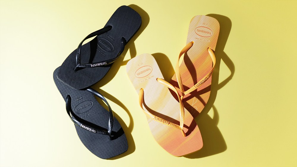 Two pairs of Havaianas flip-flops in black and orange with square toe design on yellow background