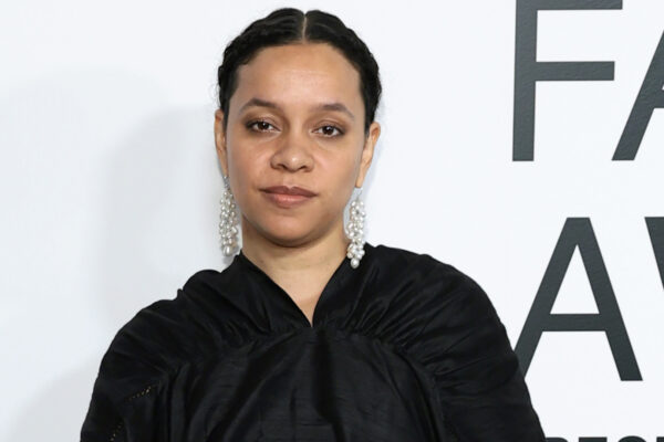 Rachel Scott of Diotima stands on a step and repeat