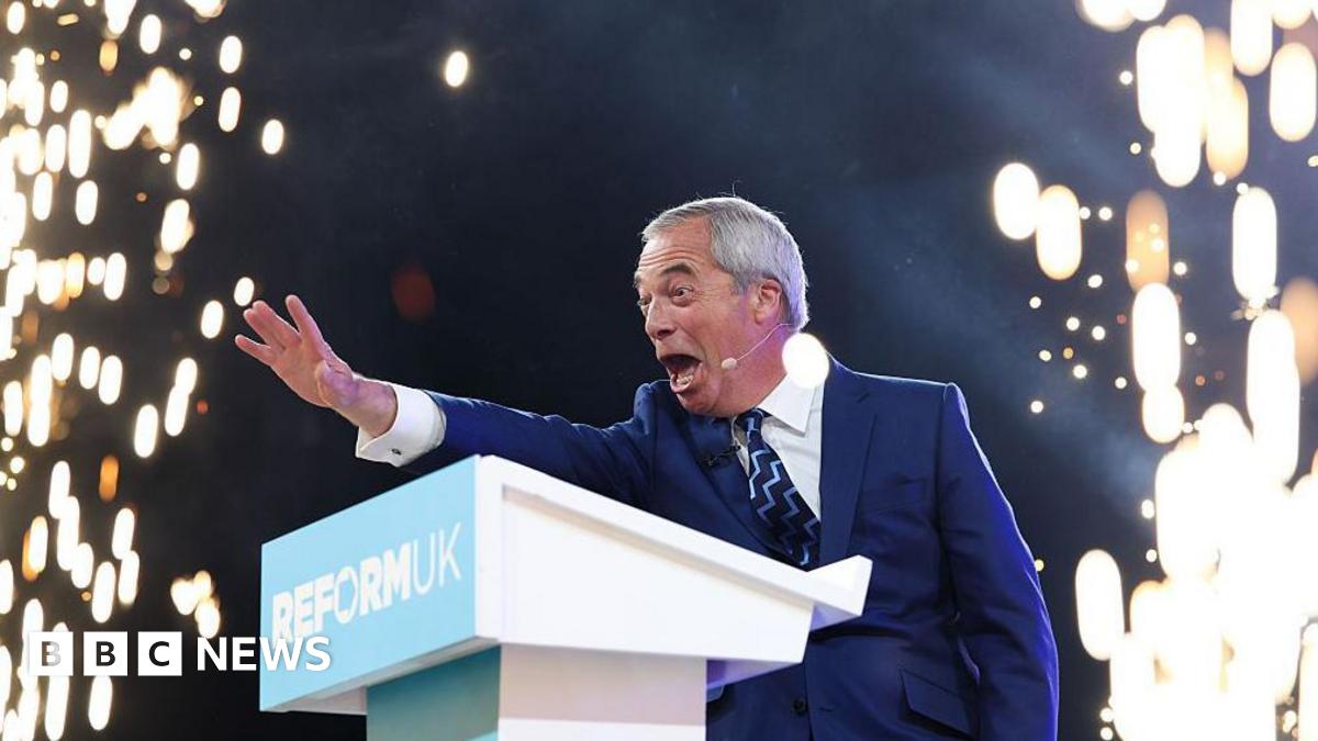 Reform UK leader Nigel Farage on stage at his party's autumn conference. He is waving at the audience at a lectern as fireworks go off around him