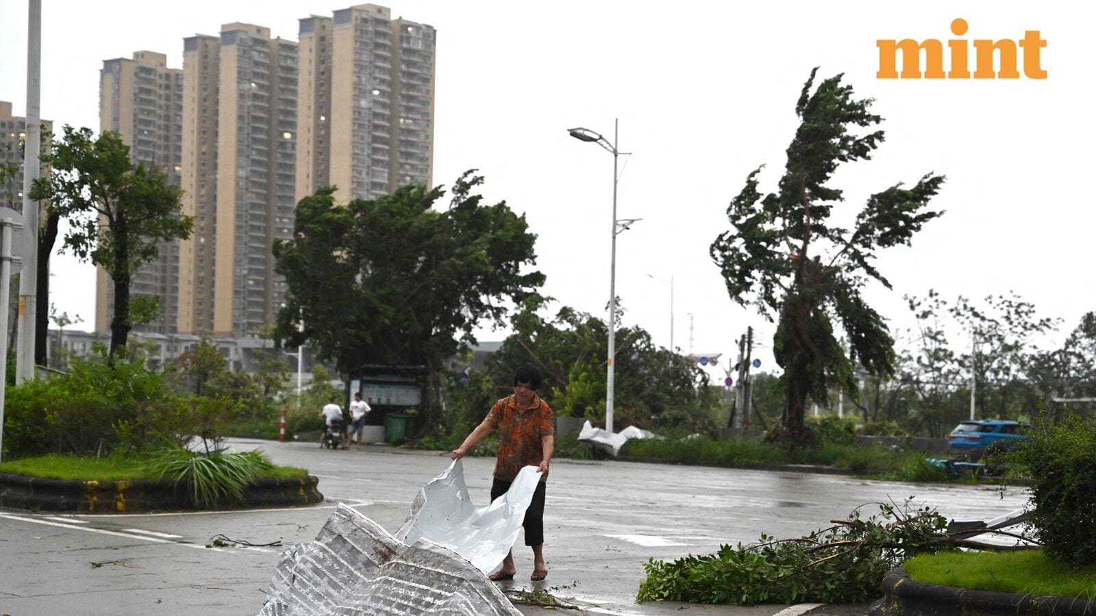 A woman clears debris after the passing of Typhoon Ragasa in Yangjiang, southern China’s Guangdong province on September 24, 2025.
