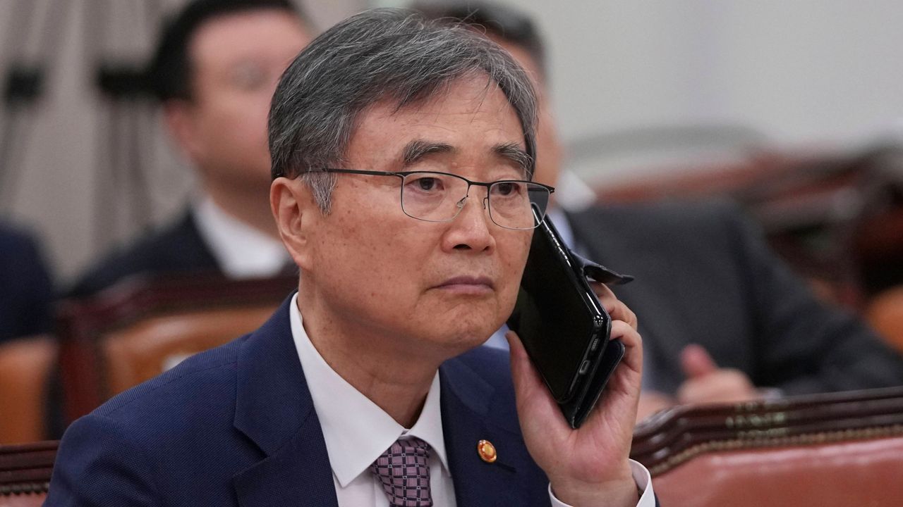 South Korean Foreign Minister Cho Hyun holds his mobile phone before a session of the Foreign Affairs and Unification Committee at the National Assembly in Seoul, South Korea, Monday, Sept. 8, 2025. (AP Photo/Lee Jin-man)