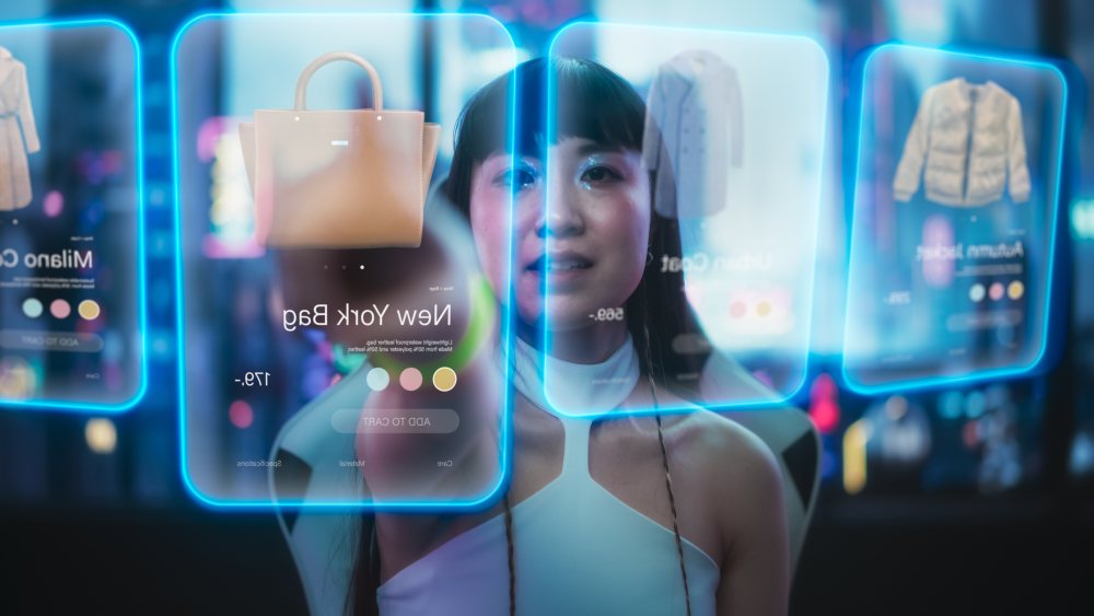Stylish woman looking at digital screen at fashion goods.