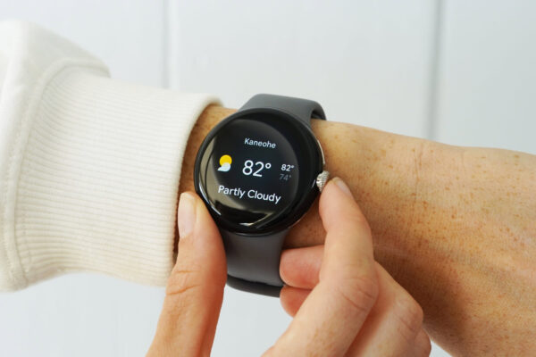 A Google Pixel Watch on a user's wrist displays the Weather tile.