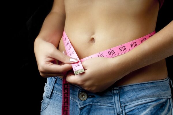 Mistakes Stopping Weight Loss Injections | GP Advice woman measures her waistline