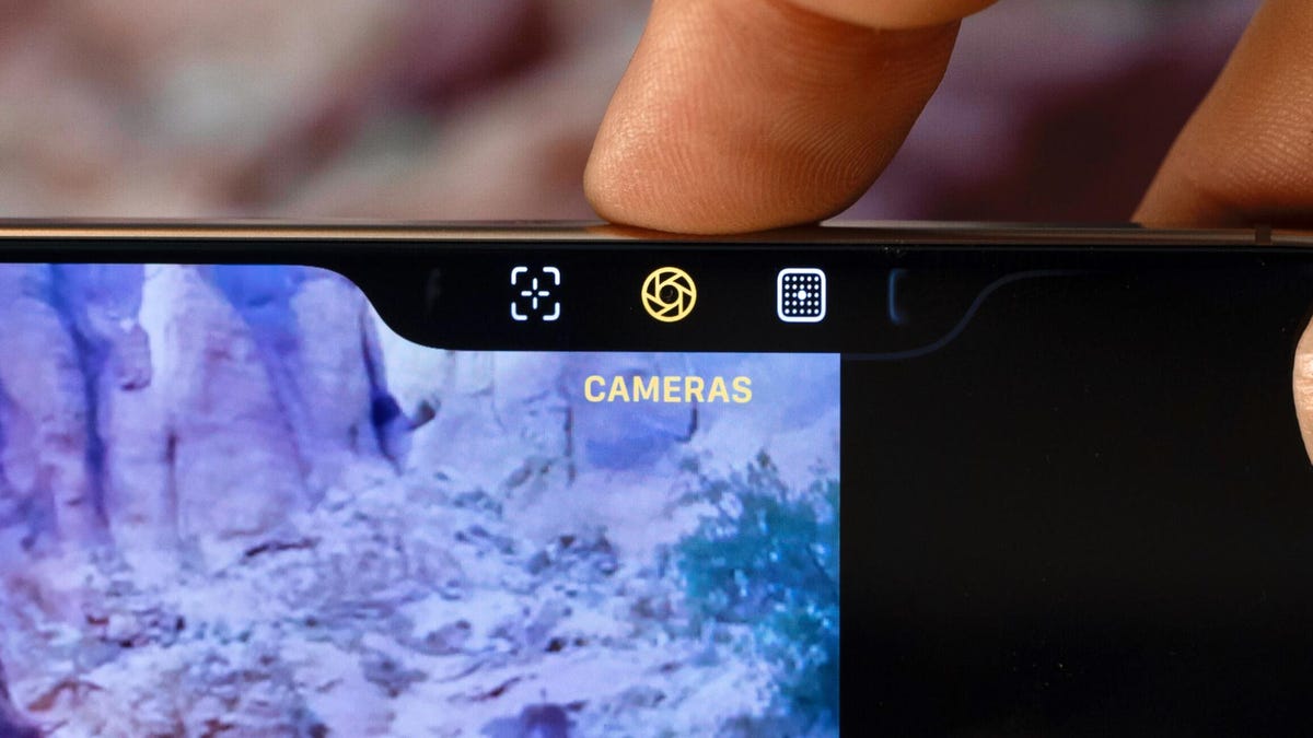A finger pressing the iPhone 16's camera control button