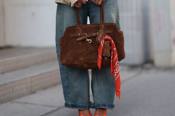 a woman carrying a brown suede bag at copenhagen fashion week