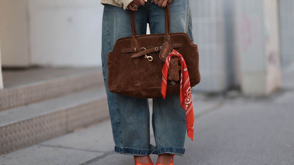 a woman carrying a brown suede bag at copenhagen fashion week