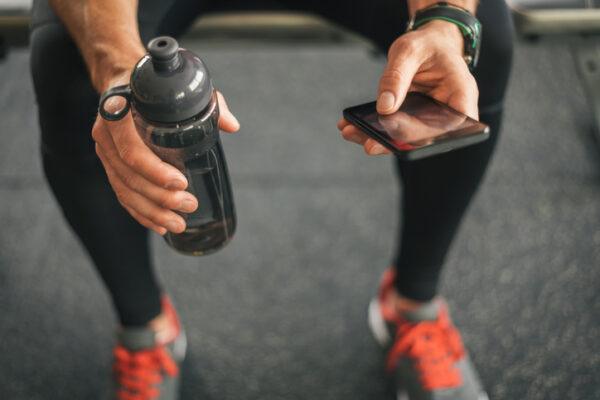 Fitness Apps Can Have a Negative Impact on Users Fitness man looking to the phone for motivation before workout