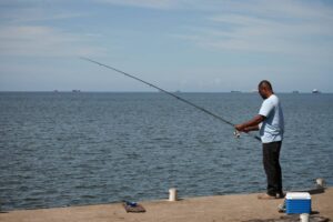 A man fishes in Cocorite, Trinidad and Tobago, Friday, Oct. 3, 2025. (AP Photo/Anselm Gibbs)