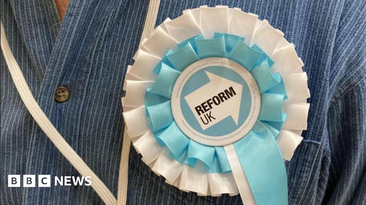 A close-up picture of a Reform UK rosette on a blue denim shirt.
