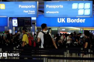 People queue up for passport control at an airport on the UK border.