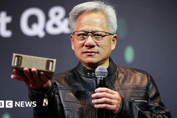 Jensen Huang, CEO of Nvidia, speaks during a news conference in Taipei in May. He is pictured holding a semiconductor unit while addressing the crowd.