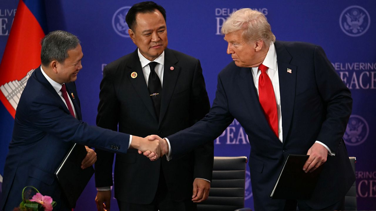 Thailand's Prime Minister Anutin Charnvirakul watches Cambodia's Prime Minister Hun Manet, left, and U.S. President Donald Trump shake hands on the sidelines of the 47th Association of Southeast Asian Nations (ASEAN) summit in Kuala Lumpur, Malaysia, Sunday, Oct. 26, 2025. (Mohd Rasfan/Pool Photo via AP)