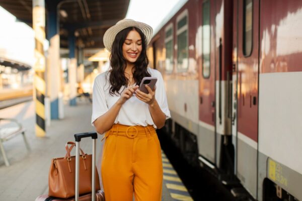 Affordable New Train Now Connects The UK’s 2 Most Stunning Cities Woman with luggage boarding train in Europe