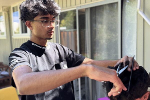 Gunn senior Reza Nasser cuts a classmate's hair in his backyard. Nasser started his business, Fadez by Reza, during his sophomore year, and encourages other aspiring entrepreneurs to start taking risks early. "If you want to start something, just go for it," Nasser said. "Don't wait for a miracle to happen or wait until your older. Just put in work and conssistecny and results will come for sure."