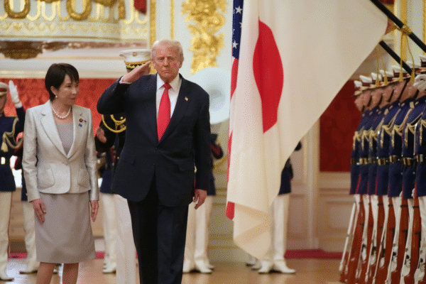 Trump salutes as he and Japanese PM Takaichi review the honor guard during at Akasaka Palace.