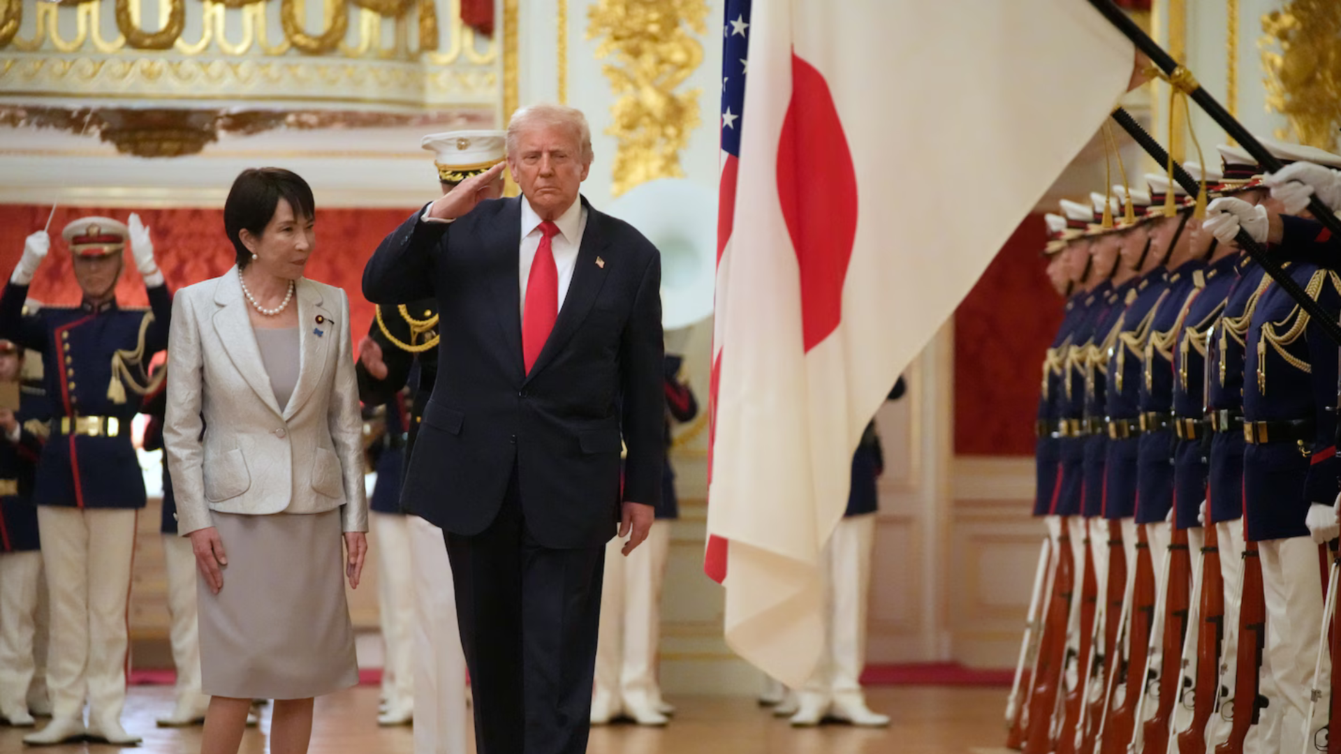 Trump salutes as he and Japanese PM Takaichi review the honor guard during at Akasaka Palace.