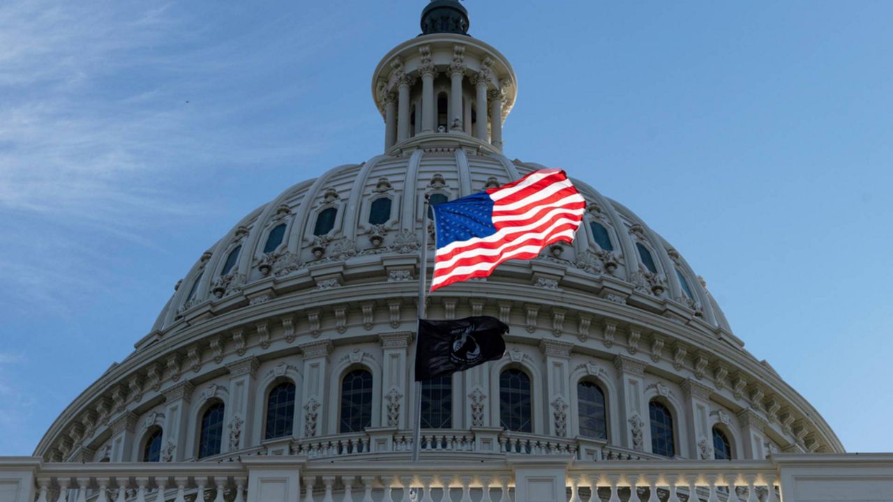 The American flag over the Capitol is illuminated by the early morning light on the first day of a government shutdown, in Washington, Wednesday, Oct. 1, 2025. (AP Photo/J. Scott Applewhite)