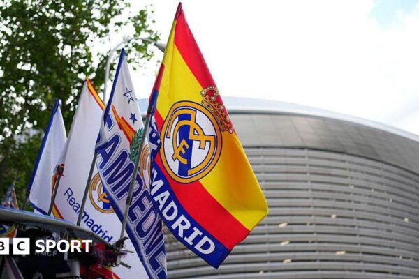 A row of Spain and Real Madrid flags fly in front of the Bernabeu stadium