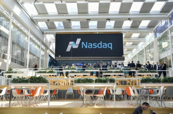 Executives gather in front of a large Nasdaq sign inside the Swedish Stock Exchange during the Traton SE listing ceremony.