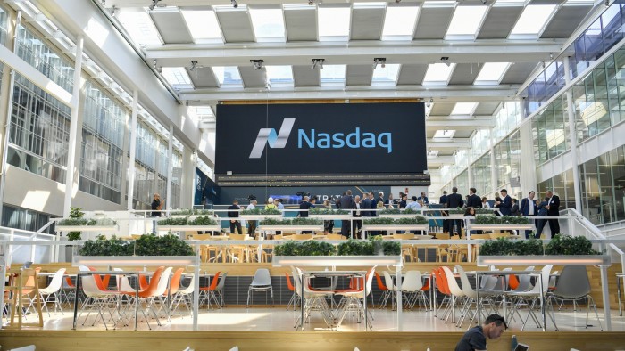 Executives gather in front of a large Nasdaq sign inside the Swedish Stock Exchange during the Traton SE listing ceremony.