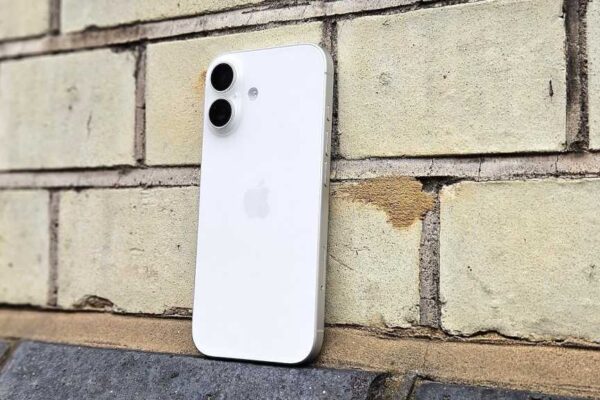 iPhone 17 in white, against a brick wall