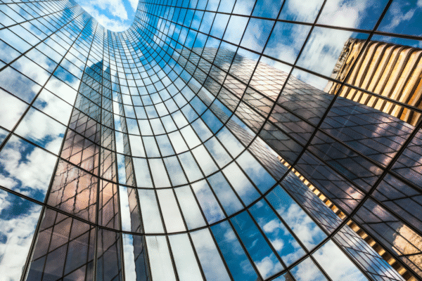 Reflection of blue sky on building glass windows with curve lines.