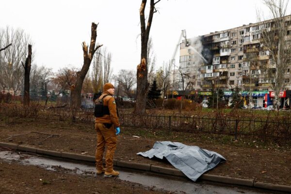 A body lies covered on a street in Kyiv on Saturday.