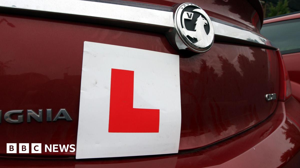 A close-up shows the back of a maroon car, which has a square "L plate" stuck on the rear of the vehicle.
