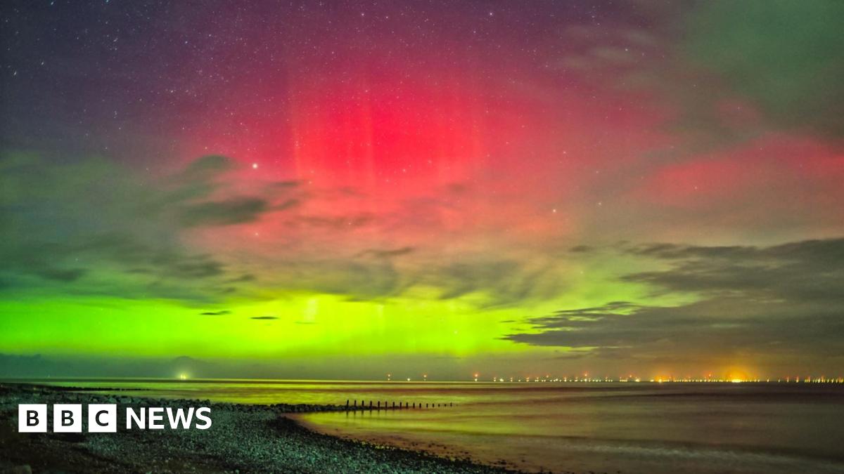 A mix of green and pink colours can be seen over the ocean.
