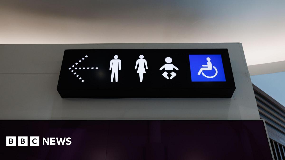 A photo shows a toilet sign with male, female, child and disabled icons