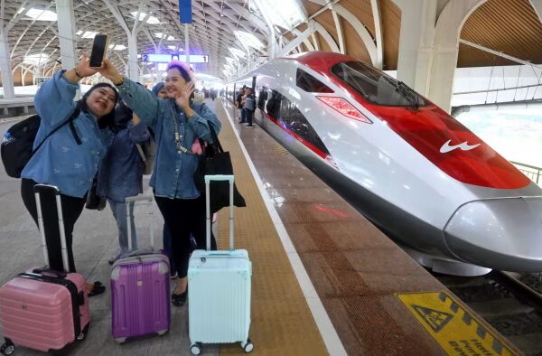 Passengers pose with a high-speed train at a station in Jakarta, Indonesia in 2025