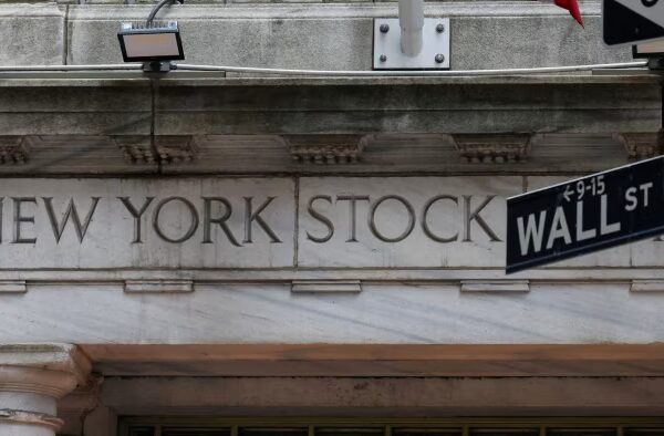 Alt text: The New York Stock Exchange entrance with a Wall Street sign in the foreground.