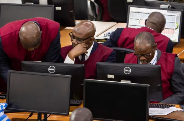Employees in matching maroon vests work at computer terminals on the trading floor of the Nigerian Stock Exchange.